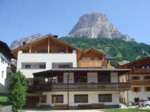 a large building with a mountain in the background at Residence Armonia in Colfosco