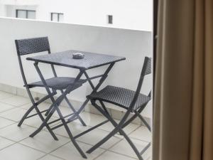 un tavolo e due sedie di fronte a un bancone di Apartamentos Esmeralda Ibiza a Ibiza Città