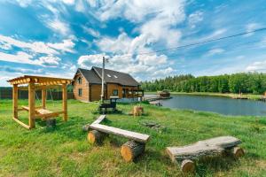 uma cabana de madeira num campo junto a um lago em GuestHouse on the Lake with Bathhouse 70 km from Kiev em Makariv