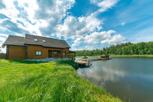 uma cabana de madeira na margem de um lago em GuestHouse on the Lake with Bathhouse 70 km from Kiev em Makariv