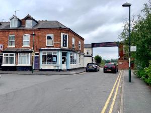 een straat met auto's geparkeerd voor gebouwen bij THE LIMES Guest House in Birmingham