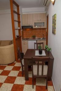 a kitchen with a table and chairs in a room at Apartmani Skver Sanja in Herceg-Novi