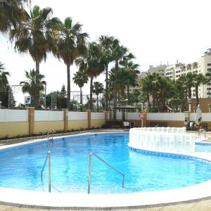 una grande piscina con palme sullo sfondo di ACV - Isla Park-1ª Linea Planta 9 Frontal Interior a Oropesa del Mar