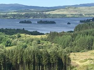 
a large body of water surrounded by trees at The Nest Glamping Pod in Dalmally
