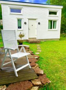 ボリホルムにあるFriesviks Gårdの家の前のデッキに座る白い椅子