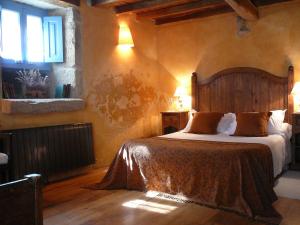 a bedroom with a bed with a wooden headboard and a window at Casa do Castelo de Andrade in Puentedeume