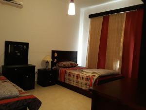 a bedroom with two beds and a television in it at Marina wadi degla villa duplex Ain Sokhna in Ain Sokhna
