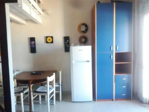 una sala da pranzo con tavolo e frigorifero di Villino Nuoro a San Teodoro