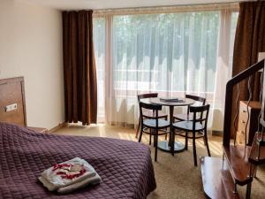 a bedroom with a bed and a table and chairs at Sancta Elena in Šventoji