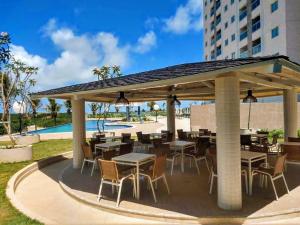 a pavilion with tables and chairs next to a pool at SALINAS PARK RESORT in Salinópolis