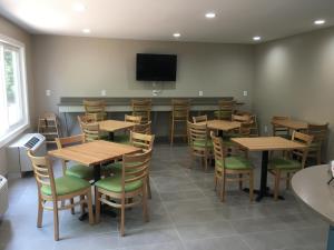 a restaurant with wooden tables and chairs and a flat screen tv at Country Inn & Suites by Radisson, Rock Hill, SC in Rock Hill