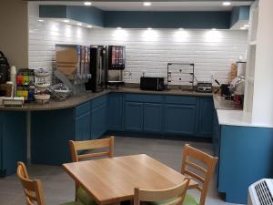 uma cozinha com armários azuis e uma mesa de madeira em Country Inn & Suites by Radisson, Rock Hill, SC em Rock Hill