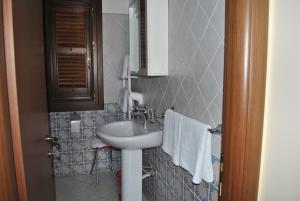 a small bathroom with a sink and a mirror at Ippocampo B&B in Licata