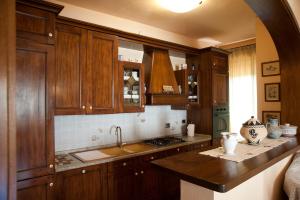 kuchnia z drewnianymi szafkami i zlewem w obiekcie Casa Donatella sulla costa degli Etruschi w mieście Rosignano Solvay