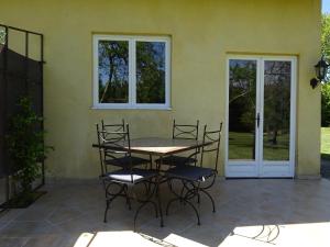 Un patio con una mesa y sillas frente a una casa. en Mas de l'AGUARELLA, en Saint-Rémy-de-Provence