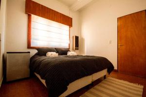 a bedroom with a bed with two towels on it at Tower Rock Puerto Deseado Standard in Puerto Deseado