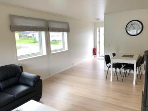 - un salon avec un canapé, une table et un réveil dans l'établissement Saltvold Leilighet nr 2, à Røldal