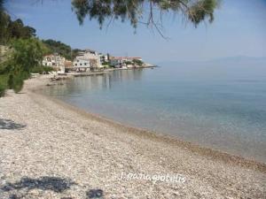 uma praia rochosa com casas e água em Abeas Samos Antonis 3 em Samos