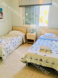 a bedroom with two beds and a window at Yiallos Village C107 in Larnaka