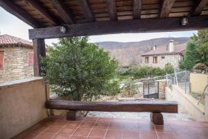 Horcajuelo de la Sierra的住宿－Los Acebos，门廊上的木凳,享有美景