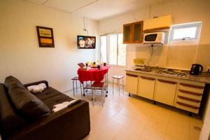 a living room with a couch and a kitchen with a table at Tower Rock Puerto Deseado Standard in Puerto Deseado
