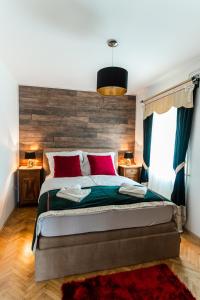 a bedroom with a large bed with red pillows at Apartments & Rooms Florjana in Bled