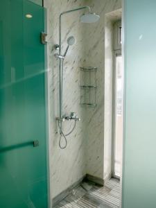 バクーにあるBoulevard Side Apartmentsのガラスドア付きの浴室のシャワー