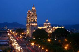a large building with a clock tower at night at Hotel Colonial in Morelia