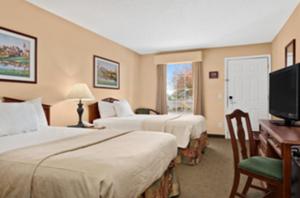 a hotel room with two beds and a television at Baymont by Wyndham Eufaula in Eufaula +26 photos