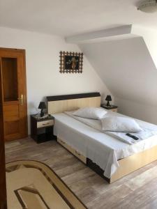 sypialnia z dużym łóżkiem z drewnianym zagłówkiem w obiekcie Pensiunea Simona w mieście Bran