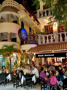 un grupo de personas sentadas en mesas en un restaurante en Hotel Cielo, en Playa del Carmen