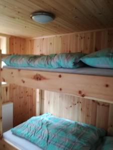 2 łóżka piętrowe w kabinie z drewnianymi ścianami w obiekcie Ferienhaus Flattnitz w mieście Flattnitz