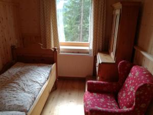 sypialnia z łóżkiem, krzesłem i oknem w obiekcie Ferienhaus Flattnitz w mieście Flattnitz