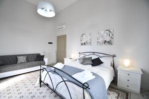 una camera bianca con un letto e un divano di Villa Camilla a Mola di Bari