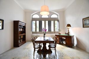 una sala da pranzo con tavolo e scrivania di Villa Camilla a Mola di Bari