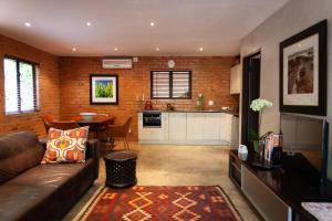 a living room with a brown couch and a kitchen at Twin Rivers Bed and Breakfast in Irene +35 photos