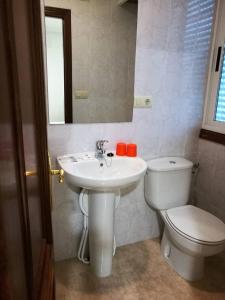 ein Badezimmer mit einem Waschbecken, einem WC und einem Spiegel in der Unterkunft PR As Termas in Bubaces