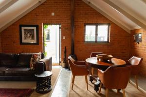a living room with a table and chairs and a brick wall at Twin Rivers Bed and Breakfast in Irene