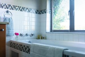 a white bathroom with a tub and a window at Twin Rivers Bed and Breakfast in Irene
