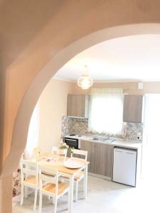 a kitchen with a table and chairs and a kitchen with an archway at Villa Bridge in Potamia