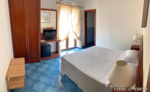a bedroom with a white bed and a television at Villa Acacia in Ponza