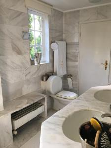 a white bathroom with a toilet and a sink at Einfamilienhaus im Landhausstil in Meerbusch