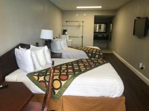 a hotel room with two beds and a television at Alamar Resort Inn in Virginia Beach