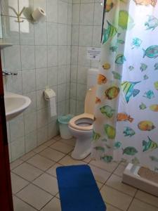 a bathroom with a toilet and a shower curtain at Angelica Apartments in Sidari
