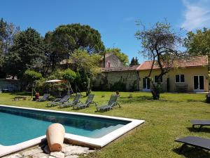 une maison avec une piscine dans la cour dans l'établissement Mas de l'AGUARELLA, à Saint-Rémy-de-Provence