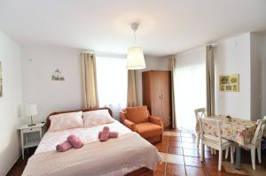 a bedroom with a bed and a chair and a table at Apartments Luni in Baška