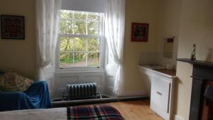 a bedroom with a window and a chair and a sink at Reenglas House in Valentia Island