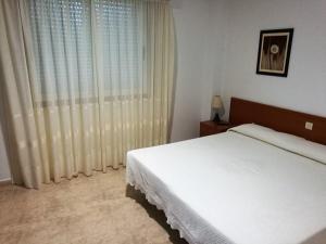 a bedroom with a white bed and a large window at PR As Termas in Bubaces