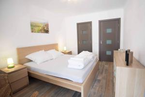 a bedroom with a bed with white sheets and pillows at Casa Zia in Făgăraş