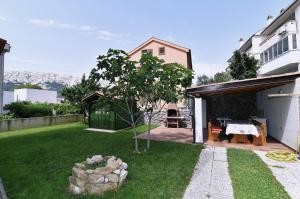 a backyard with a table and a tree at Apartments Luni in Baška